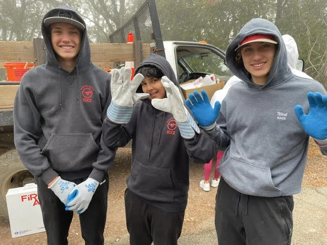 Volunteers wearing work gloves during an outdoor cleanup