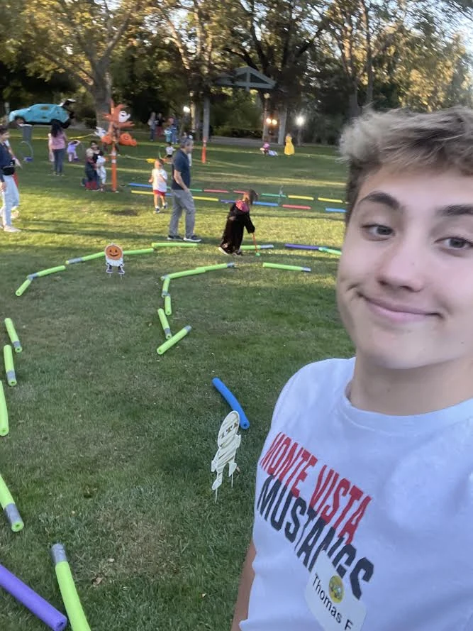 Tommy at an outdoor fall event with games and Halloween decorations