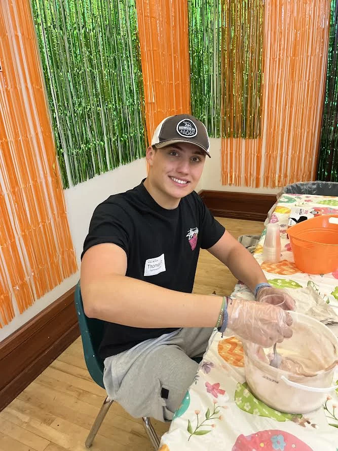 Tommy volunteering at a table during a spring community event