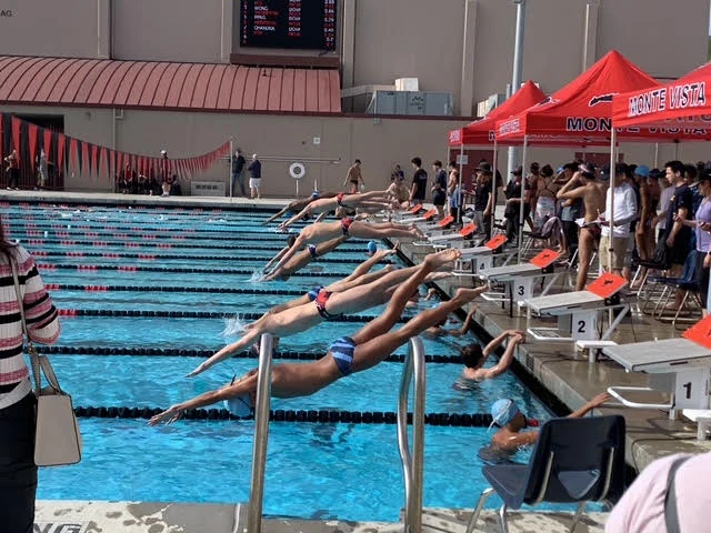 Swimmers leaving the starting blocks at a Monte Vista meet